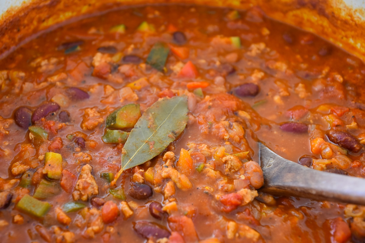 pot of turkey chili and vegetables with spoon