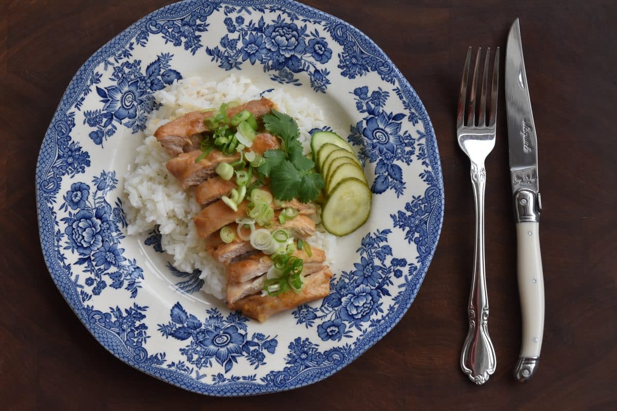 A plate of miso chicken along with a fork and knife