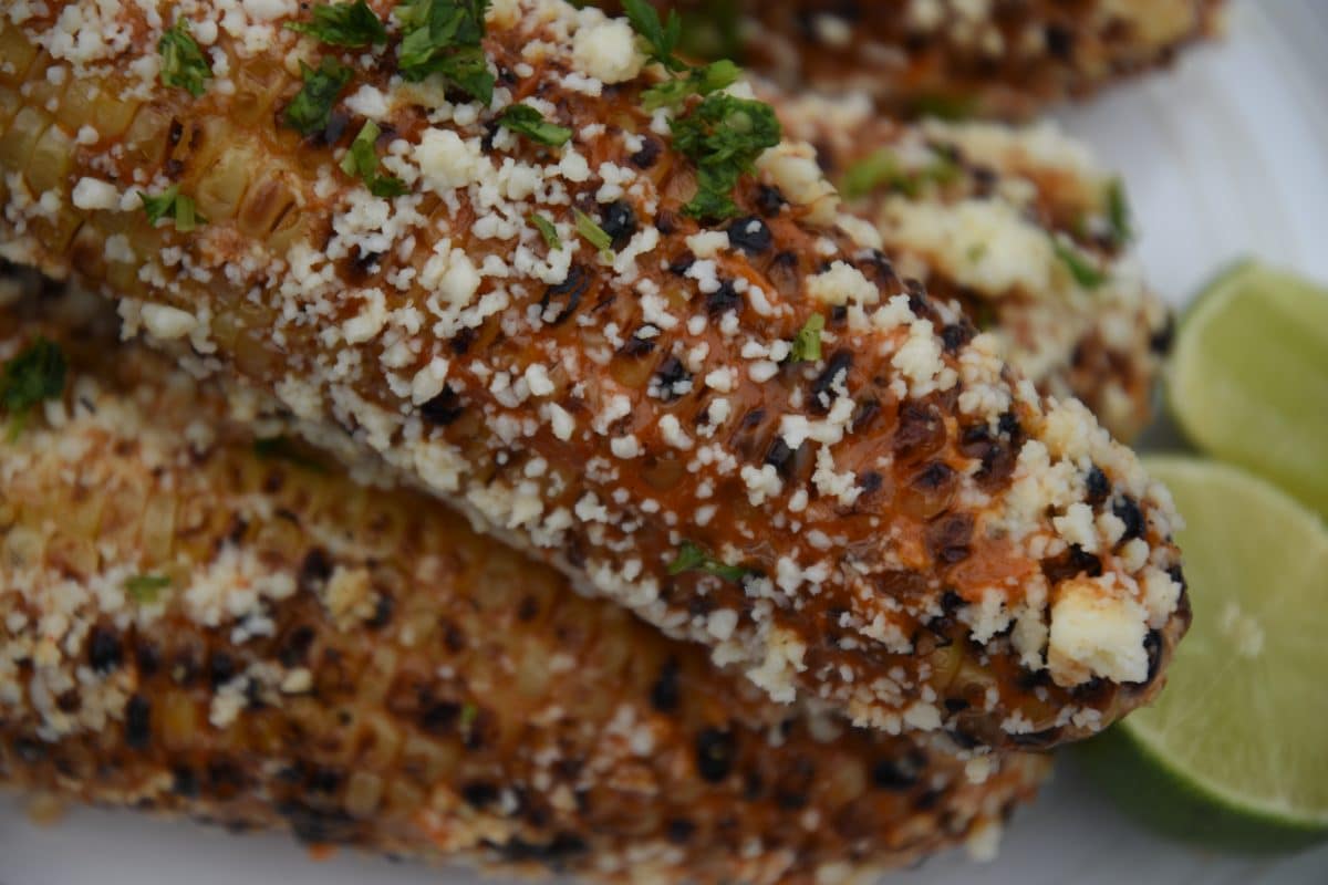 close up of chipotle grilled corn on a white platter